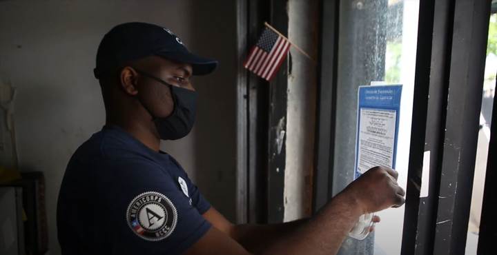 Omar Lloyd, FEMA Corps team Gulf 4 member, hangs a flyer while canvassing in Philadelphia, Pennsylvania.