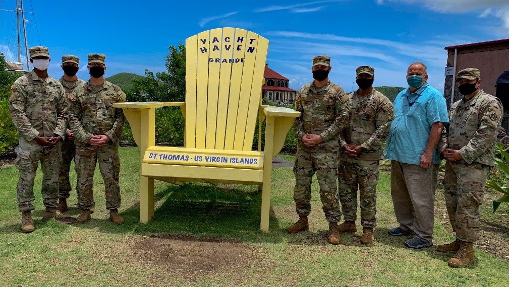 Alpha Company of the 249th Engineer Battalion of the U.S. Army Corps of Engineers team members (from left) Spc. Kodjo Akoloh, Sgt. Austin Peterson, Sgt. Adam Miller, Staff Sgt. Stephen Scott, Master Sgt. Victor Walker, FEMA's Chris Gallagher, Operations Branch Director for the Region 2 Incident Management Assistance Team, and battalion member Sgt. Eduardo Delacruz gather outside the Area Recovery Office in Yacht Haven Grande. 