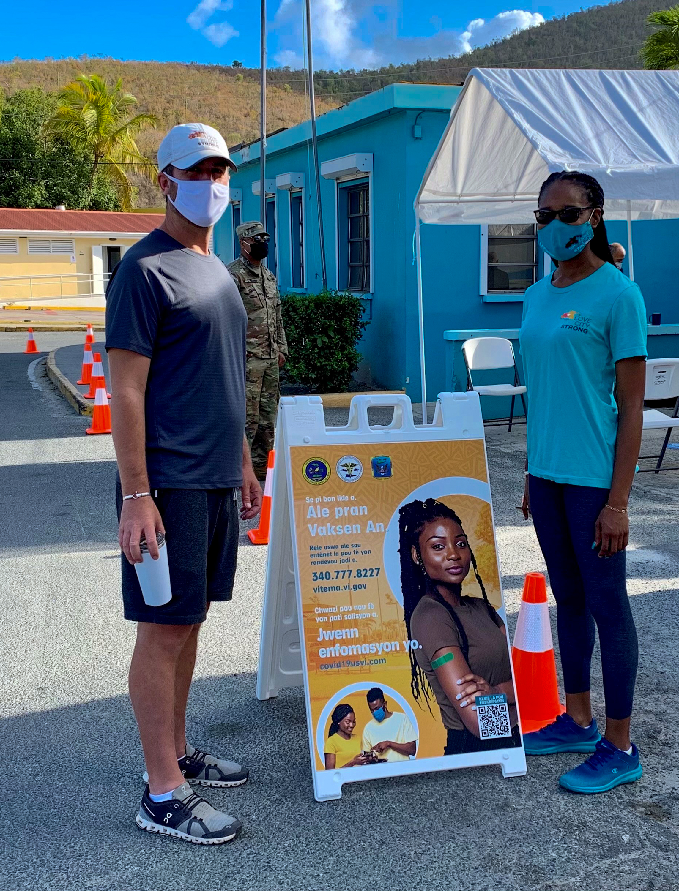 A man standing one side of the sign and a woman on the other