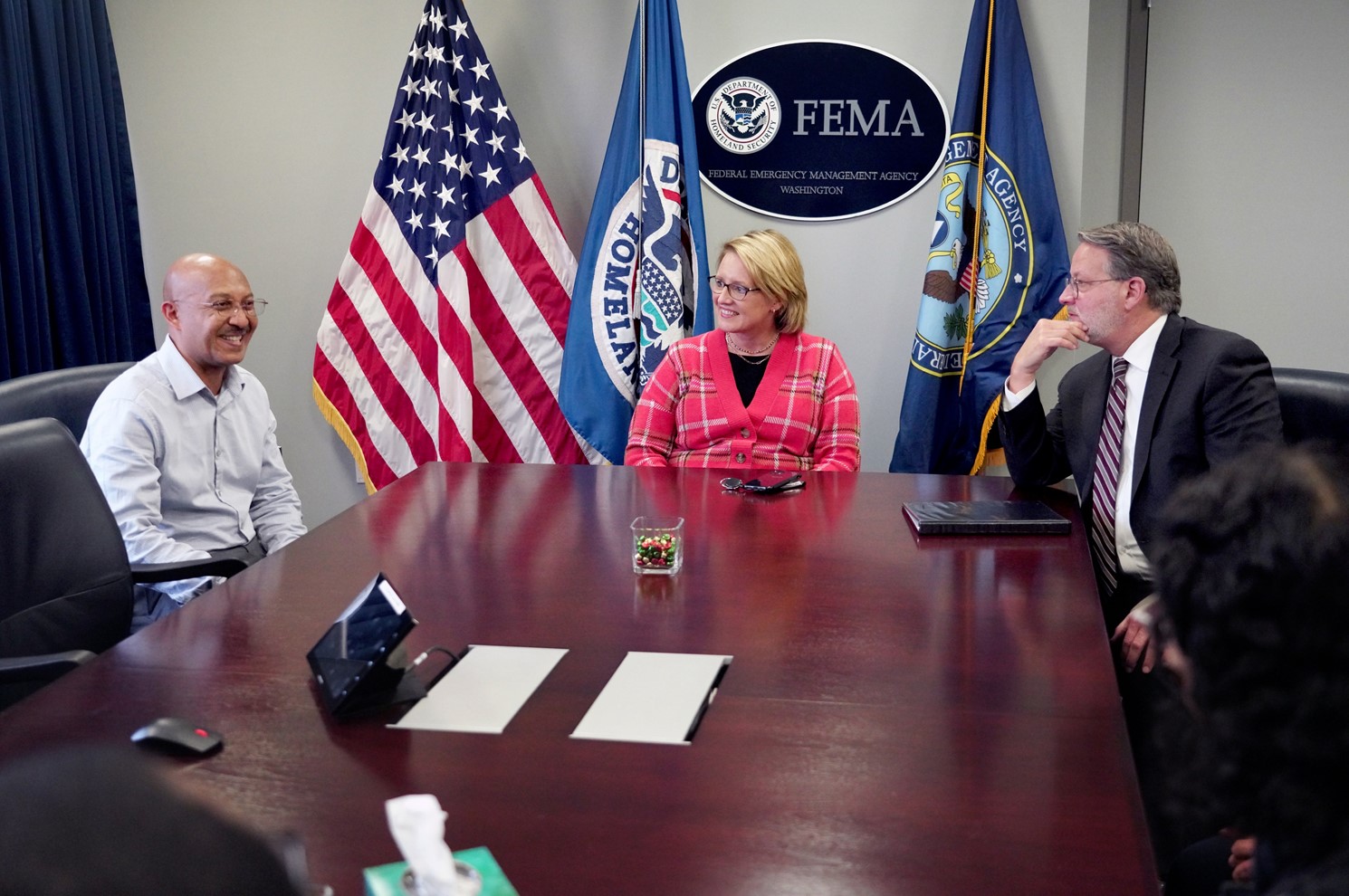 FEMA Administrator Deanne Criswell (right, center) and Sen. Gary Peters (left, center) meet with FEMA staff from Michigan after announcing funding for the Safeguarding Tomorrow Revolving Loan Fund grant program.