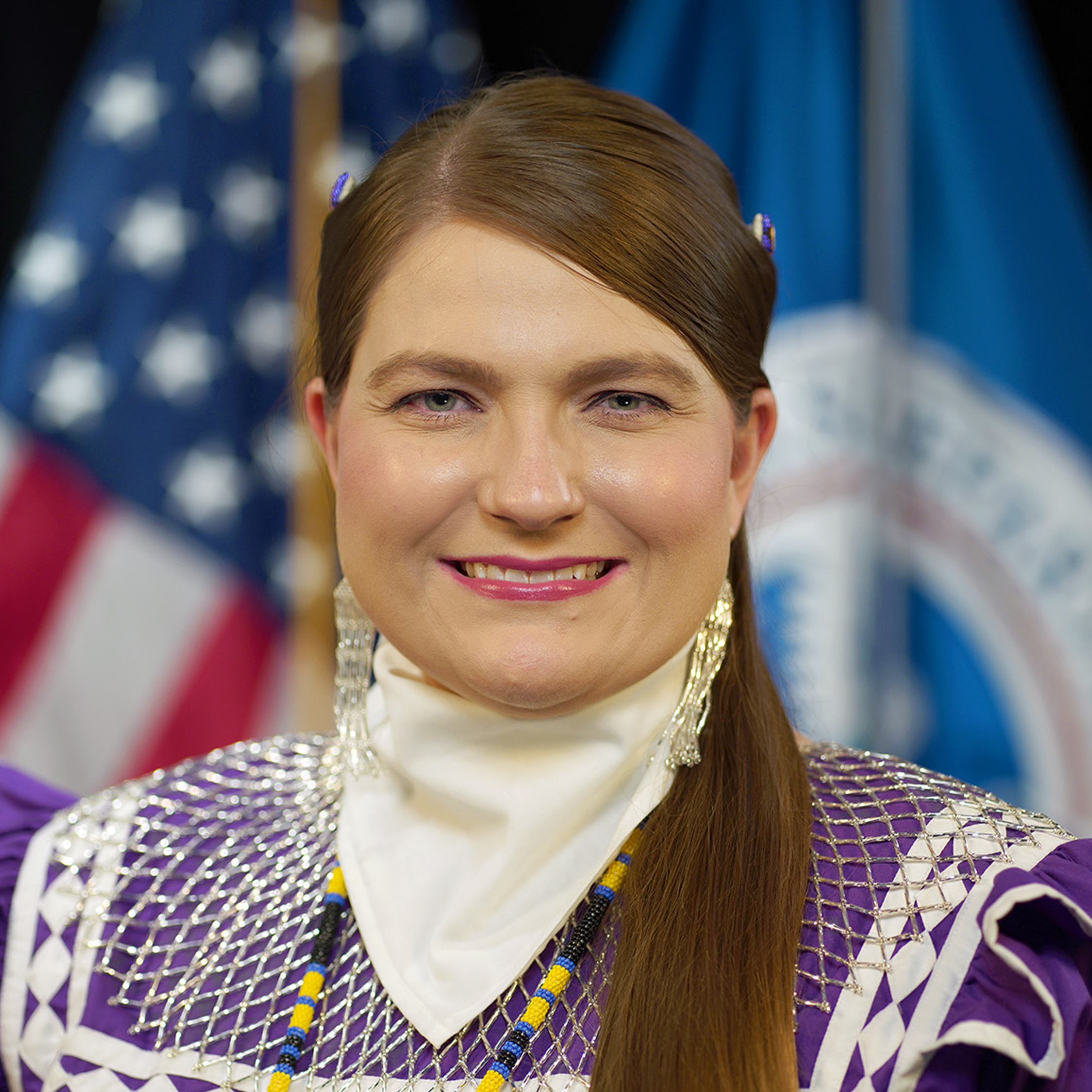 Kelbie Kennedy Smiling woman standing in front of the US flag
