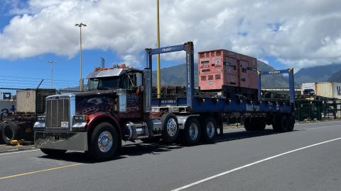 Image with caption: Maui, Hawaii (Aug. 13, 2023) - The first of 32 generators arrive at the FEMA staging area in Maui.