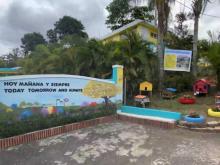 Entrance to the Comerio Family Welfare Association; flower pots made of red, blue and yellow recycled tires