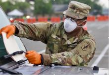 A male solider putting a folder on a car window shield