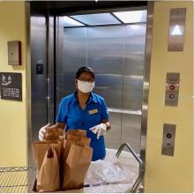 A women behind a cart of bags
