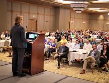 FEMA Administrator Deanne Criswell speaking in front of a crowd of people in a ball room