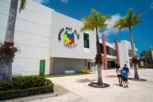 White building with multi-color sign and brick color columns.