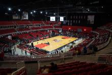 Inside of coliseum with view of basketball court and seats.