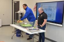 Emilio Perez and Jose Ruvira  pointing into a clear tub