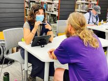 A FEMA Disaster Survivor Assistance team member provides registration services for Hurricane Ian survivors at the Disaster Resource Center located at the Lakes Regional Library. 
