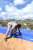  Man nails plastic sheet to roof